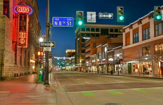 A lit downtown Boise street in the evening, looking along 8th Street