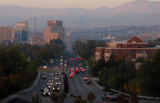 A road running into downtown Boise with the dry foothills behind it
