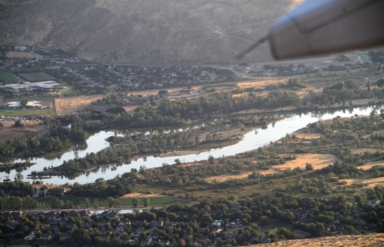 The Boise River winding through the green valley floor from the air
