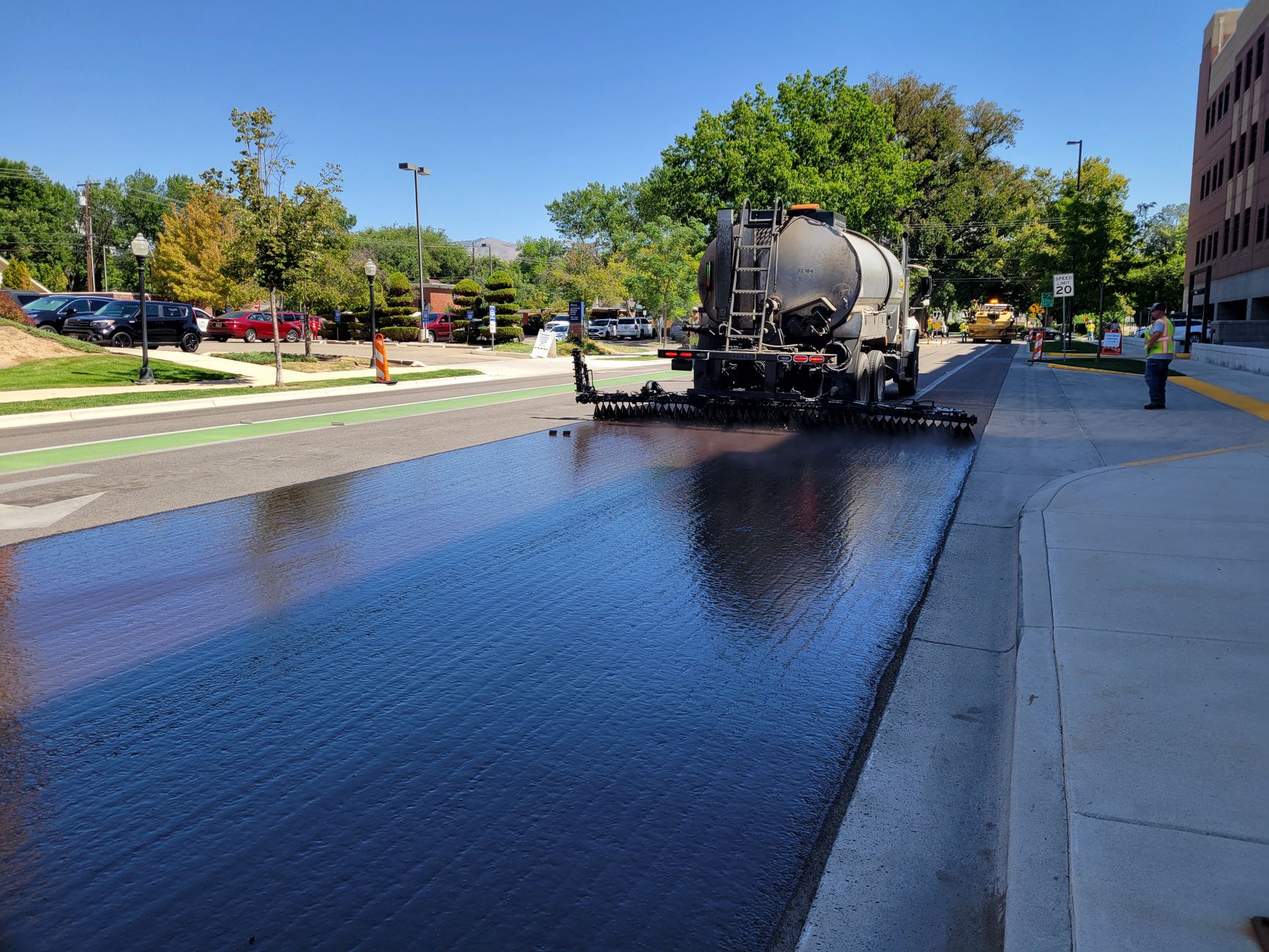 Asphalt truck paving a street in Boise, Idaho, on a sunny day, illustrating What Is Boise's Public Transport Like for Residents