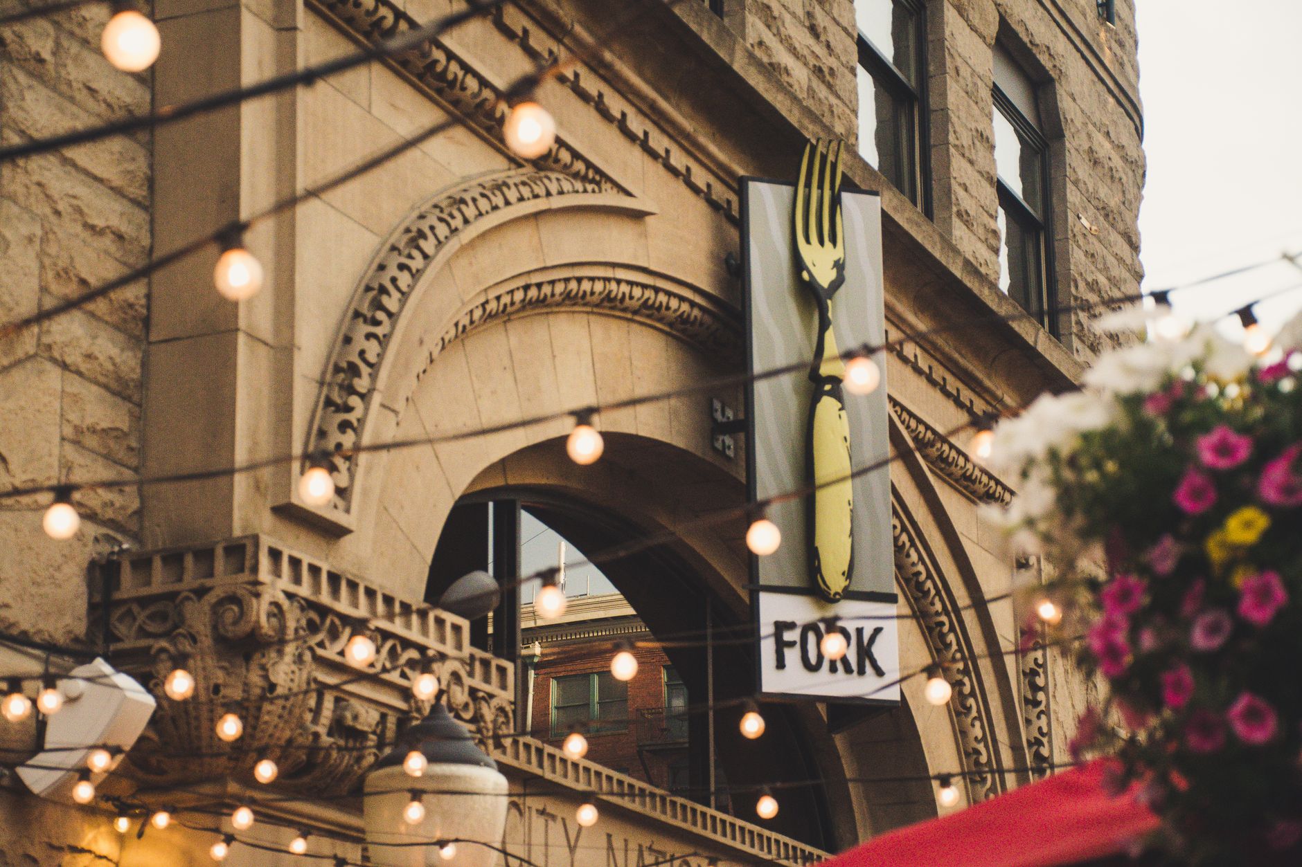 Elegant archway of Fork restaurant in Boise, Idaho with lights and flowers, illustrating What Is the Capital City Public Market in Boise