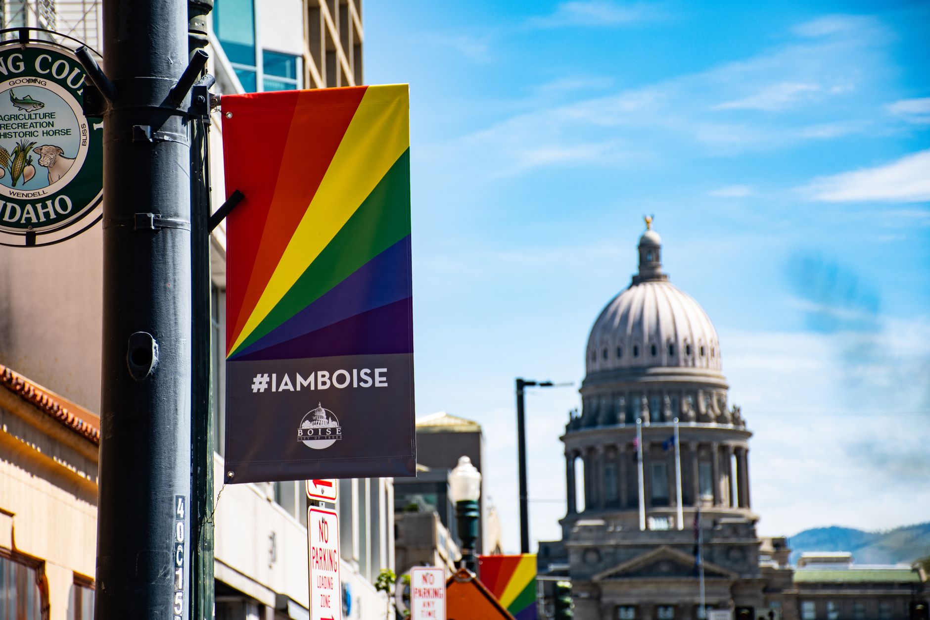 View of the Boise Capitol building with a rainbow pride banner in bright daylight, illustrating How Do You Dress for a Boise Day in Any Season