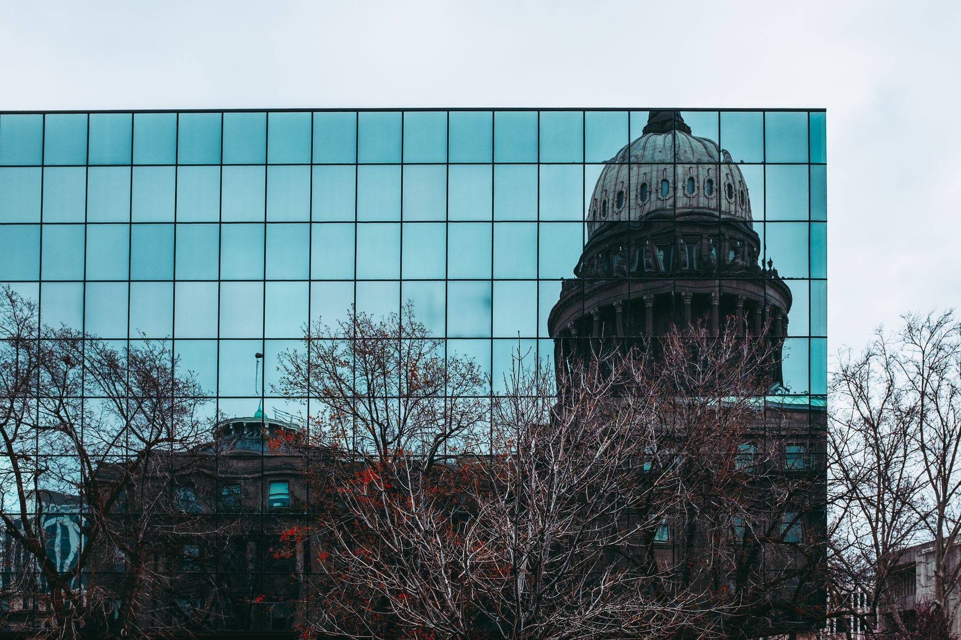 Reflection of Idaho State Capitol in a mirrored building facade in Boise, ID, illustrating How Do You Dress for a Boise Day in Any Season
