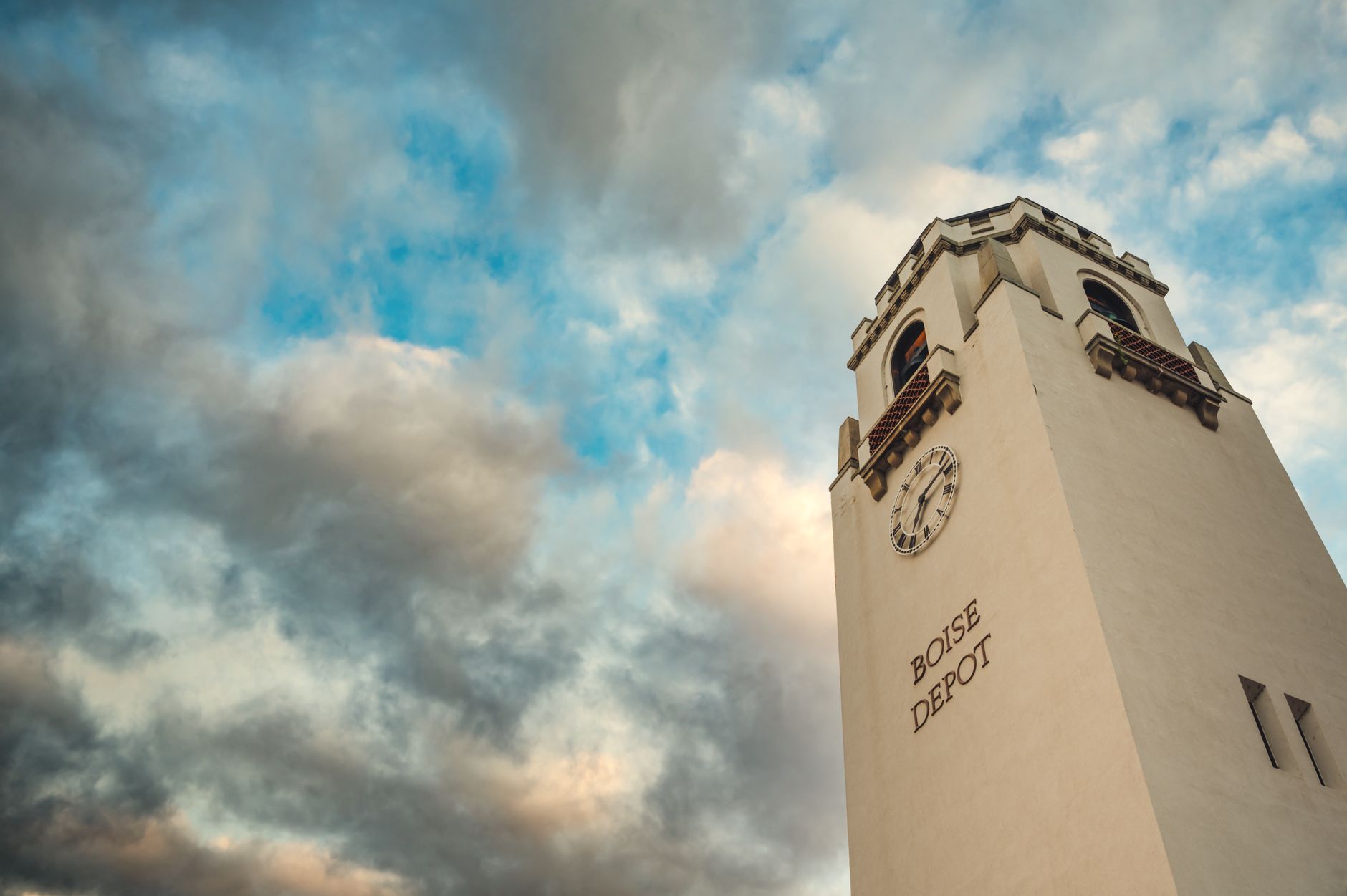 From below of aged tower with arched windows and clock of Boise Depot train station against picturesque cloudy sky, illustrating What Is the Idaho Military History Museum in Boise